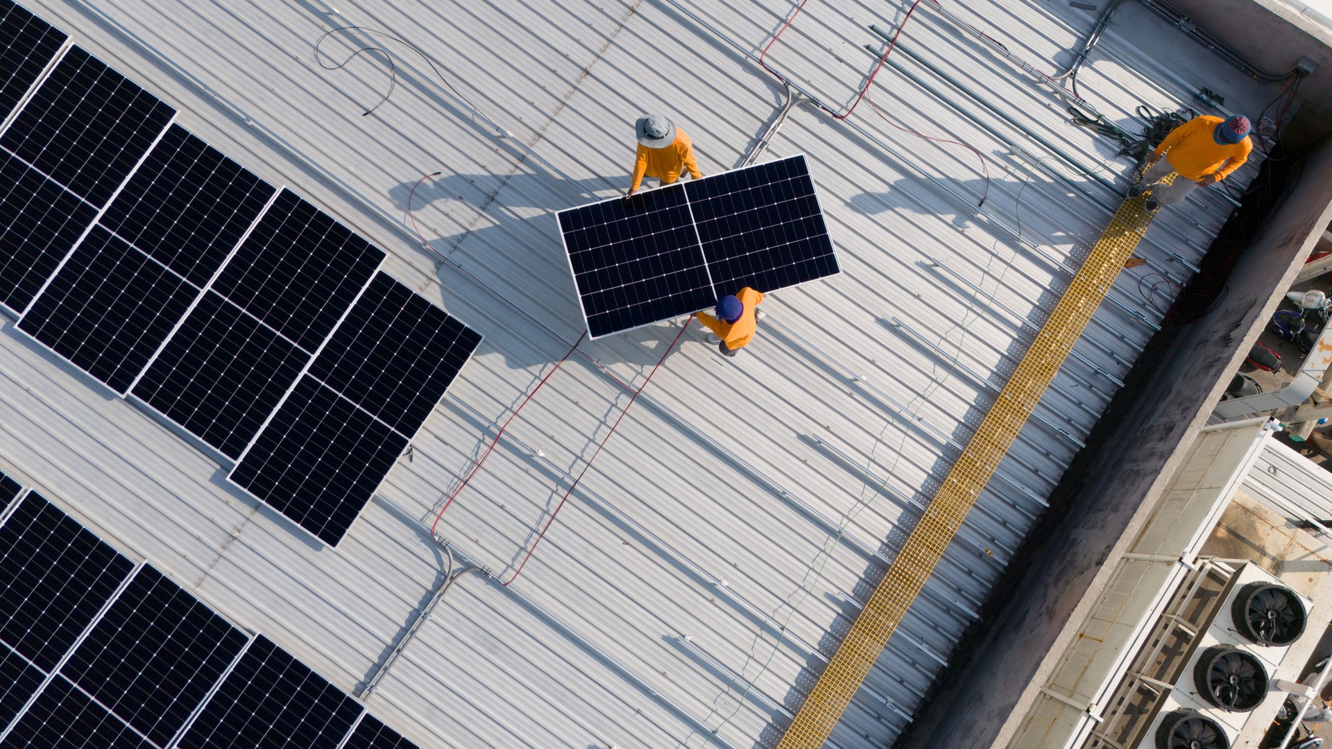 Aerial top view of a technician drone installing solar panels on the roof. Aerial top view of a technician drone installing solar panels on the roof.